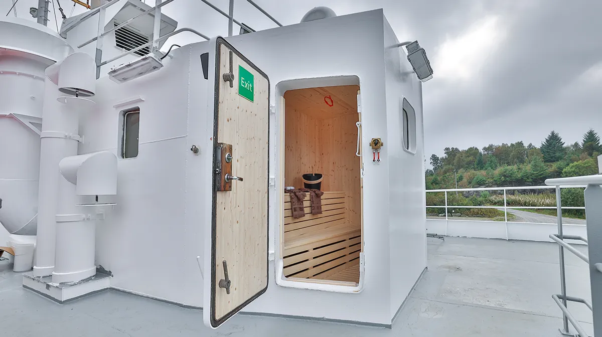 Entrance to sauna on the deck of Vikingfjord expedition vessel showing interior wooden benches and deck area