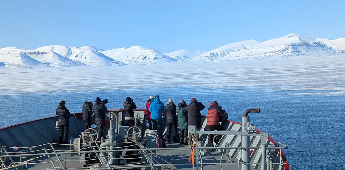 Expedition guests observing Arctic scenery from the deck of Vikingfjord vessel